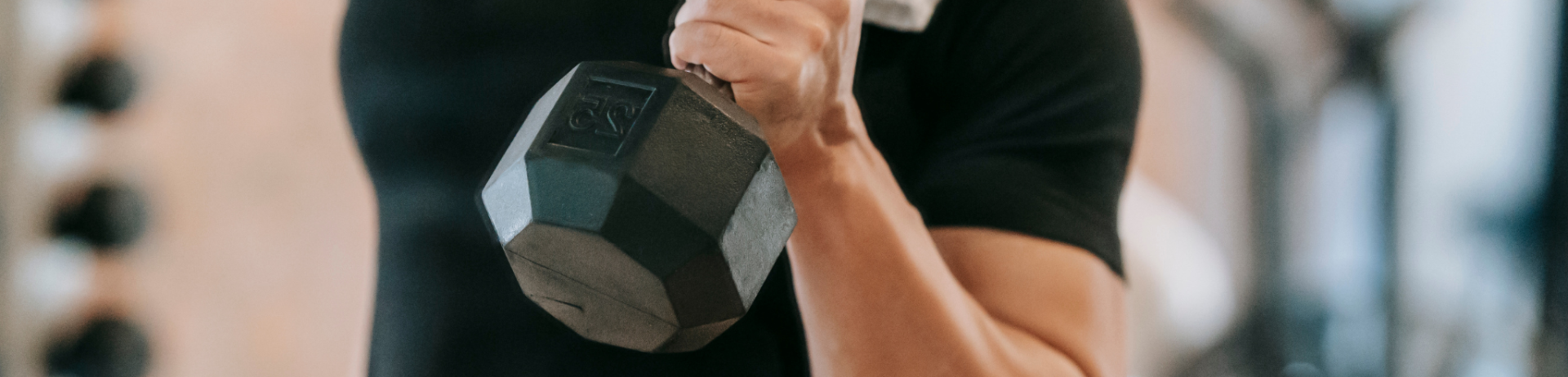 A man in a black t-shirt lifting a weight.
